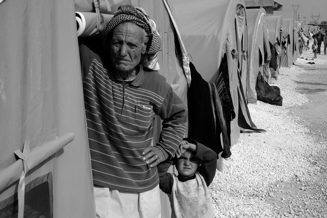 who-we-are Black and white image of refugees in a camp, highlighting humanity and resilience.
